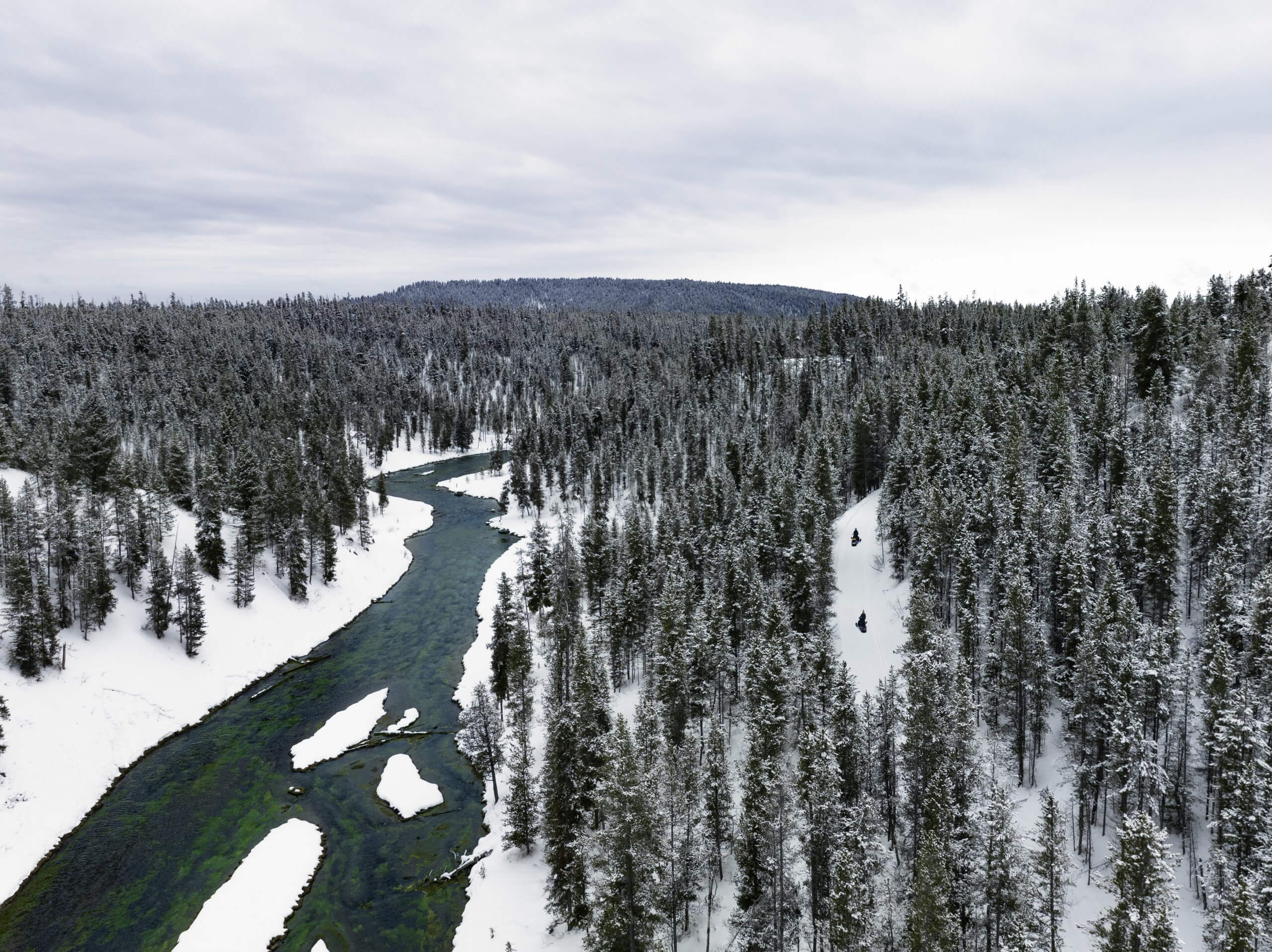 Aerial view of snowmobilers navigating a winter trail from Driggs to Mesa Falls with Teton Valley Adventures.