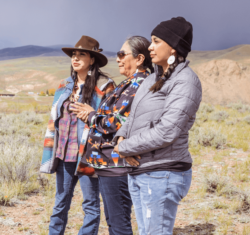 Three Native women at Chief Tendoy Monument near Tendoy, Idaho, honoring the legacy of a revered leader.