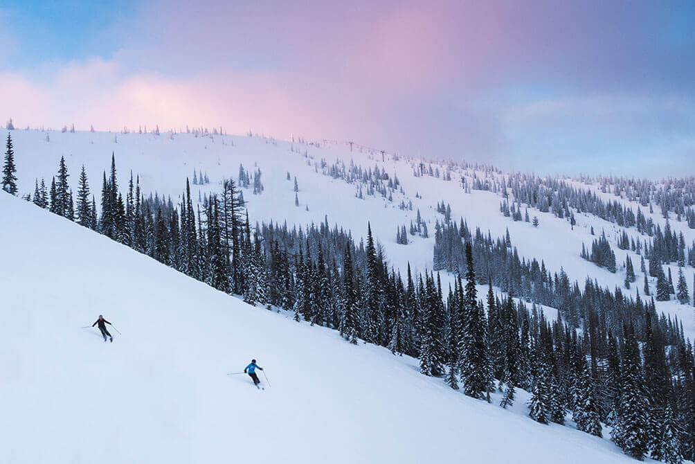 Two skiiers on mountain trail at Schweitzer.