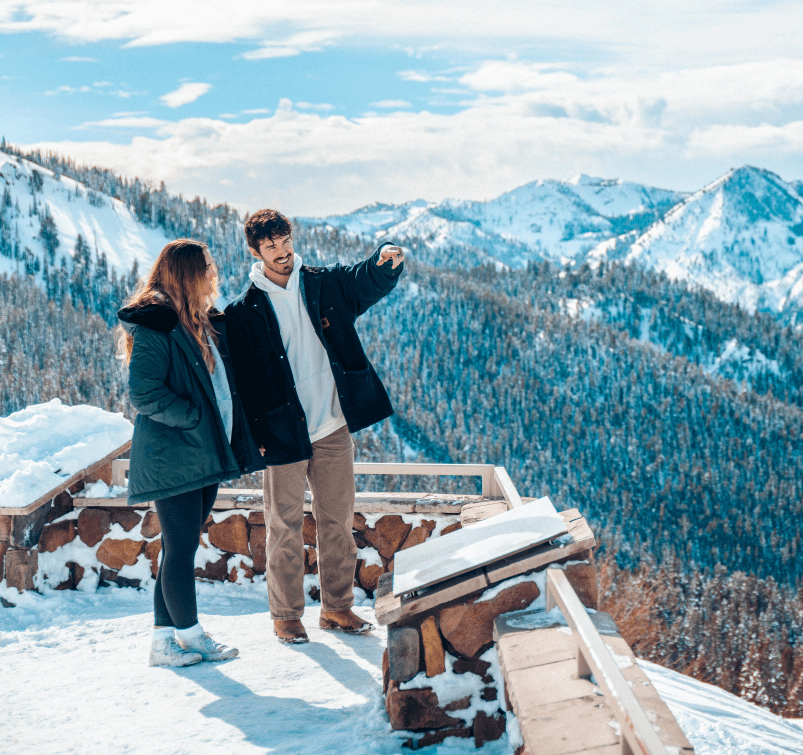 Two onlookers experiencing the snow-capped mountain vistas at Galena Summit Overlook near Stanley, Idaho.