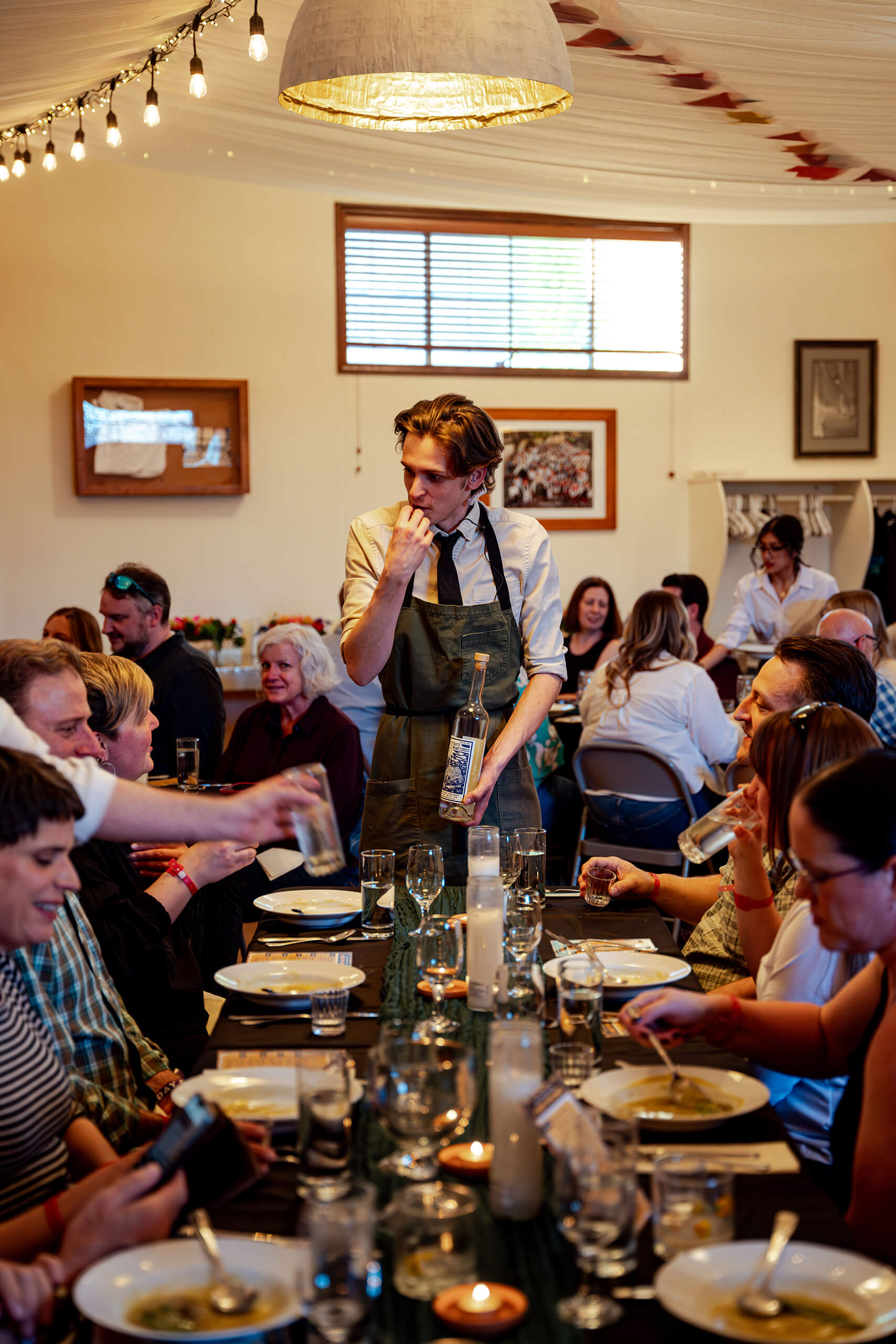 A waiter presents a bottle of wine during Foodfort at Treefort.