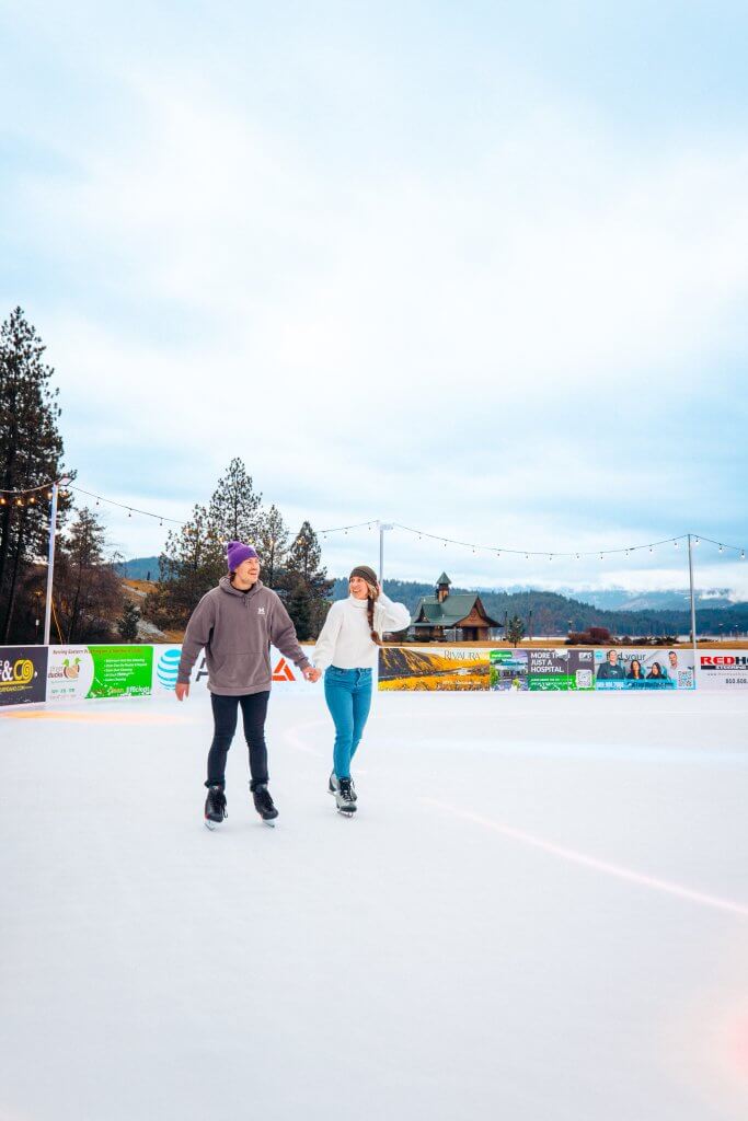 Two people holding hands and skating on the rink at the rink at CDA on Ice.