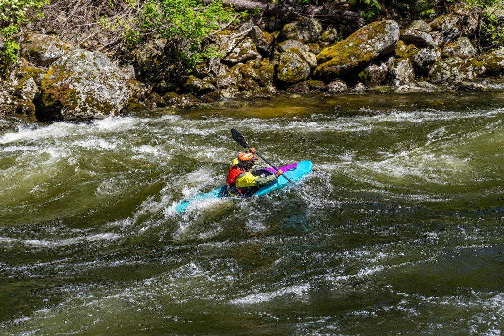 Kayaker paddling through whitewater on the St. Joe River.