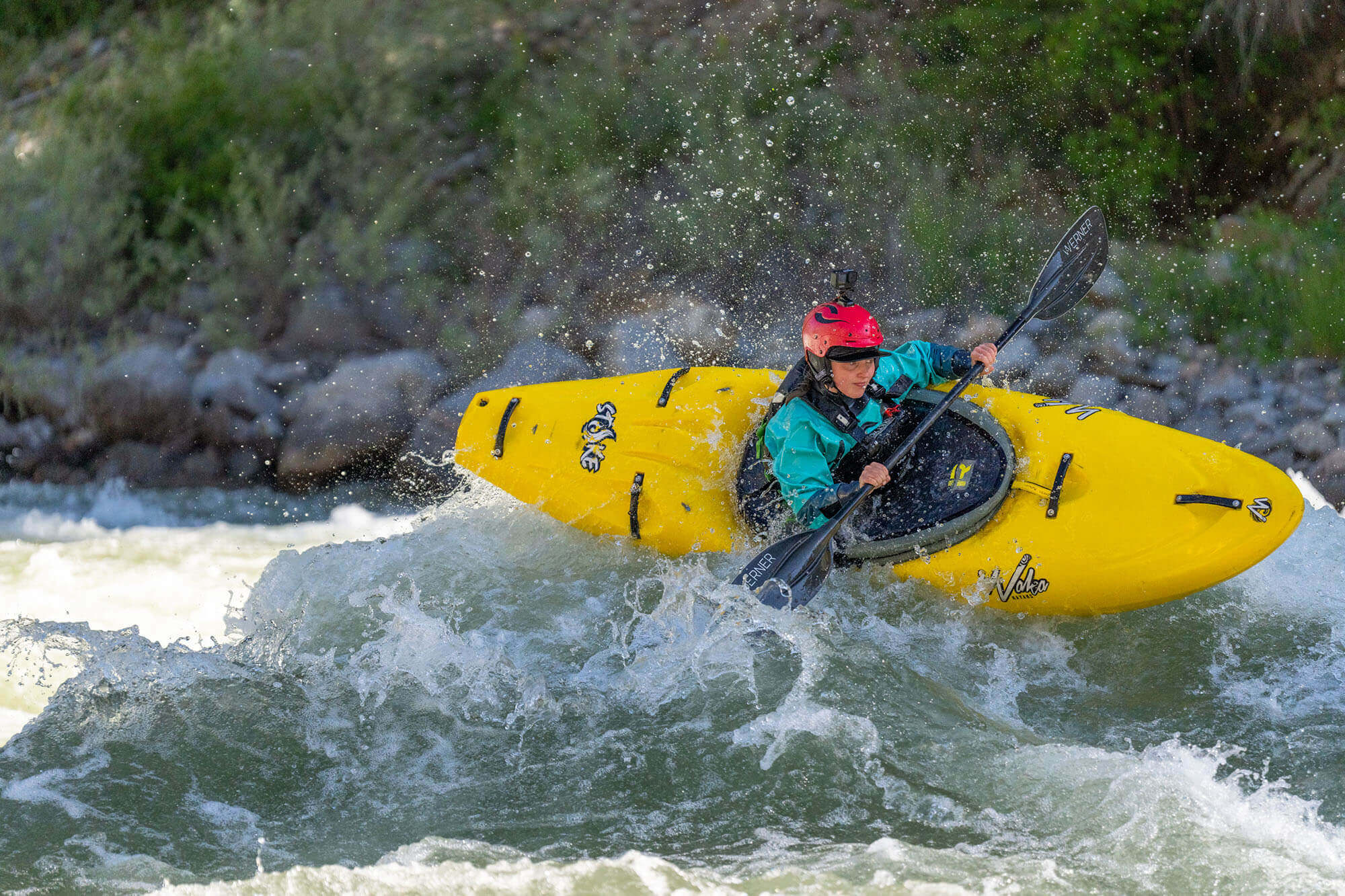 A professional kayaker steers sideways on the North Fork of the Payette River, water splashing in a thrilling turn.