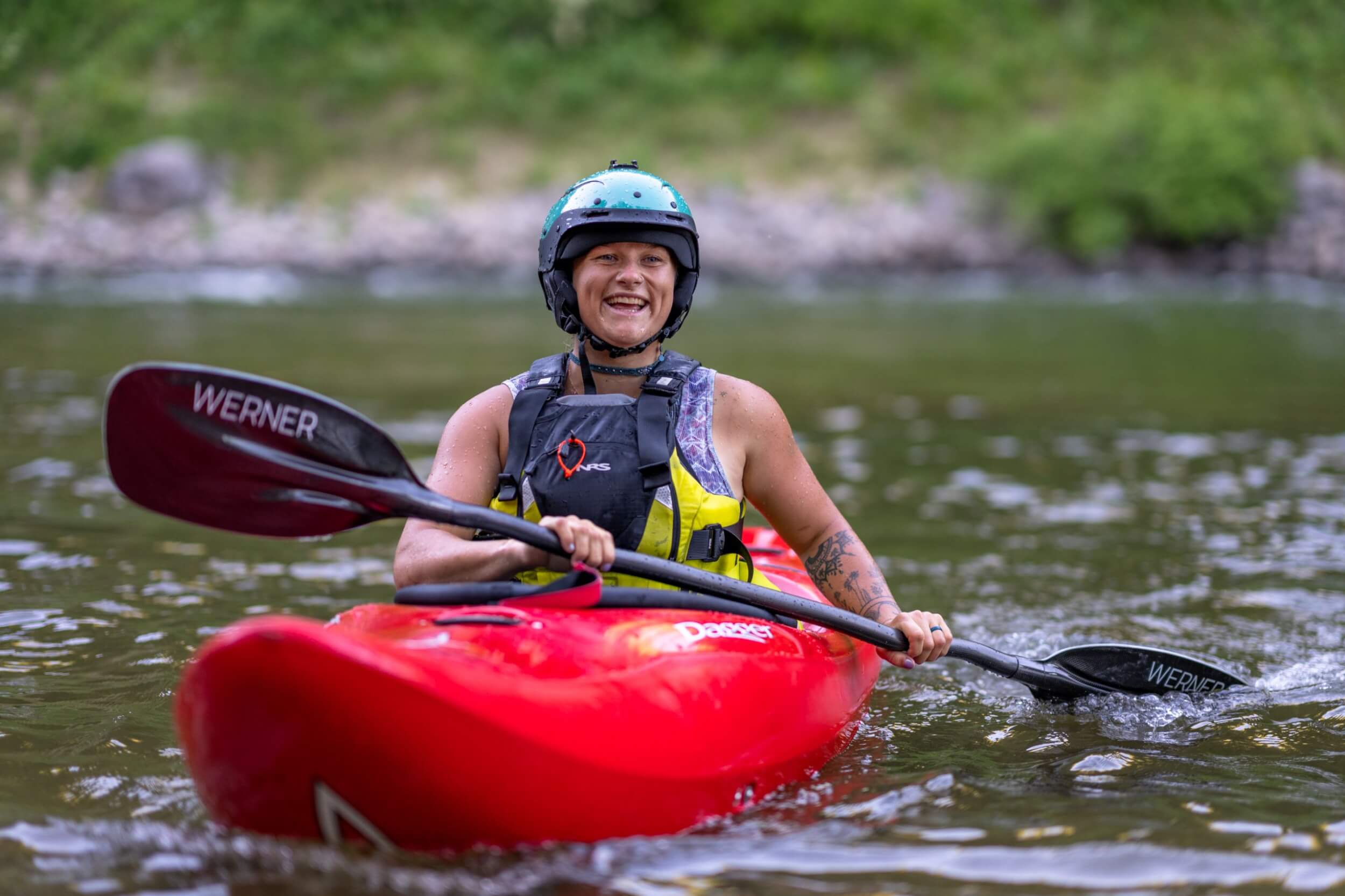 Sage Donnelly in a red kayak with blue helmet on the North Fork of the Payette River