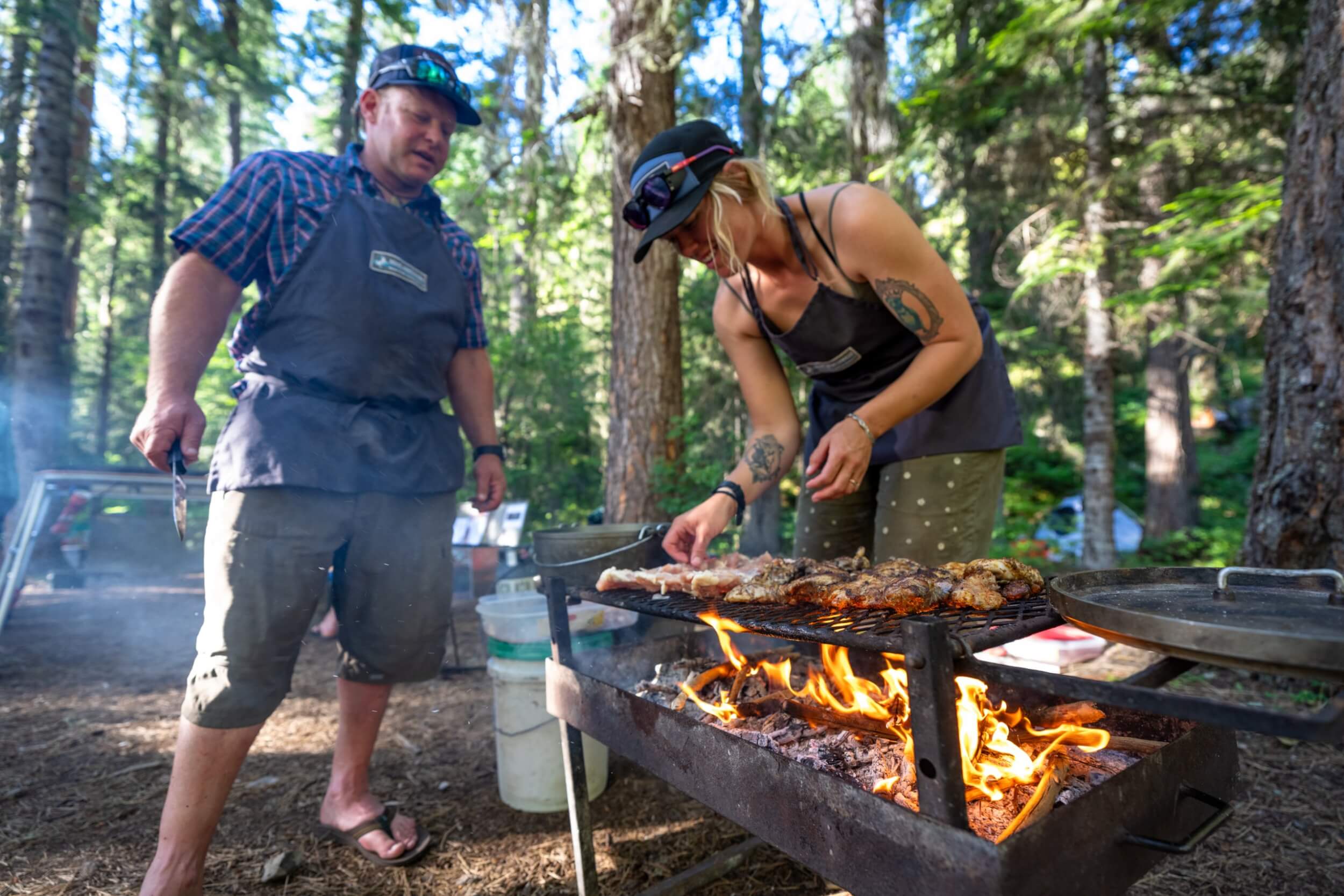 Guides cooking over an open fire at Moose Creek Campground on the Selway River with SOAR Northwest