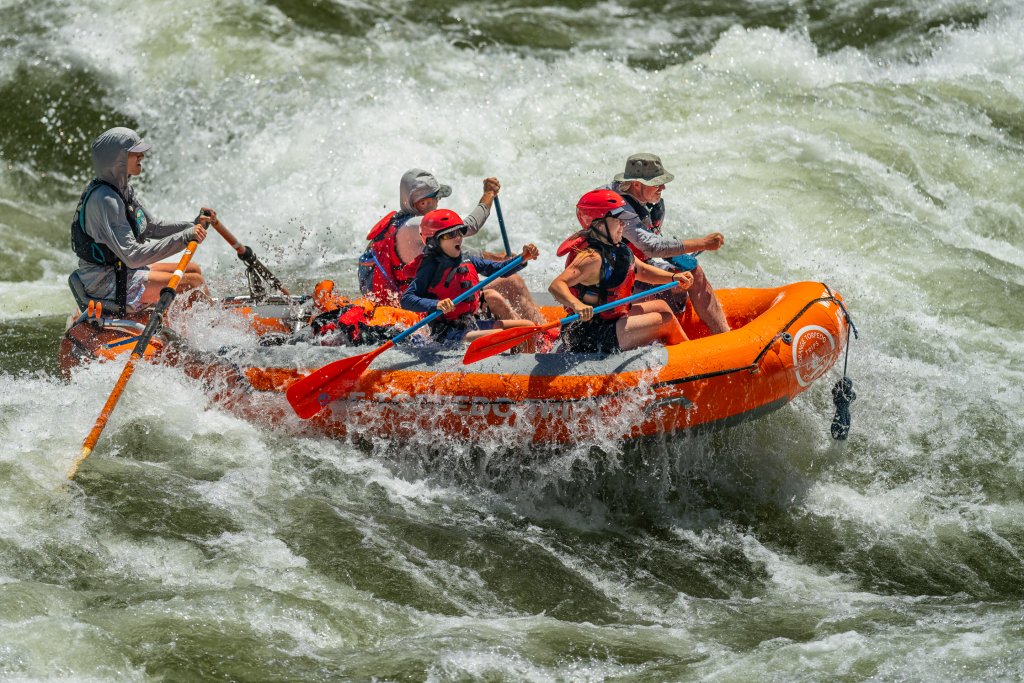 Orange Torpedo Trips raft crashing through rapids on the Main Salmon River