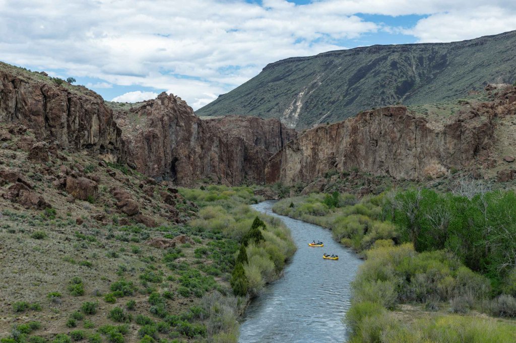 Yellow rafts floating downstream along the scenic Bruneau River canyon.