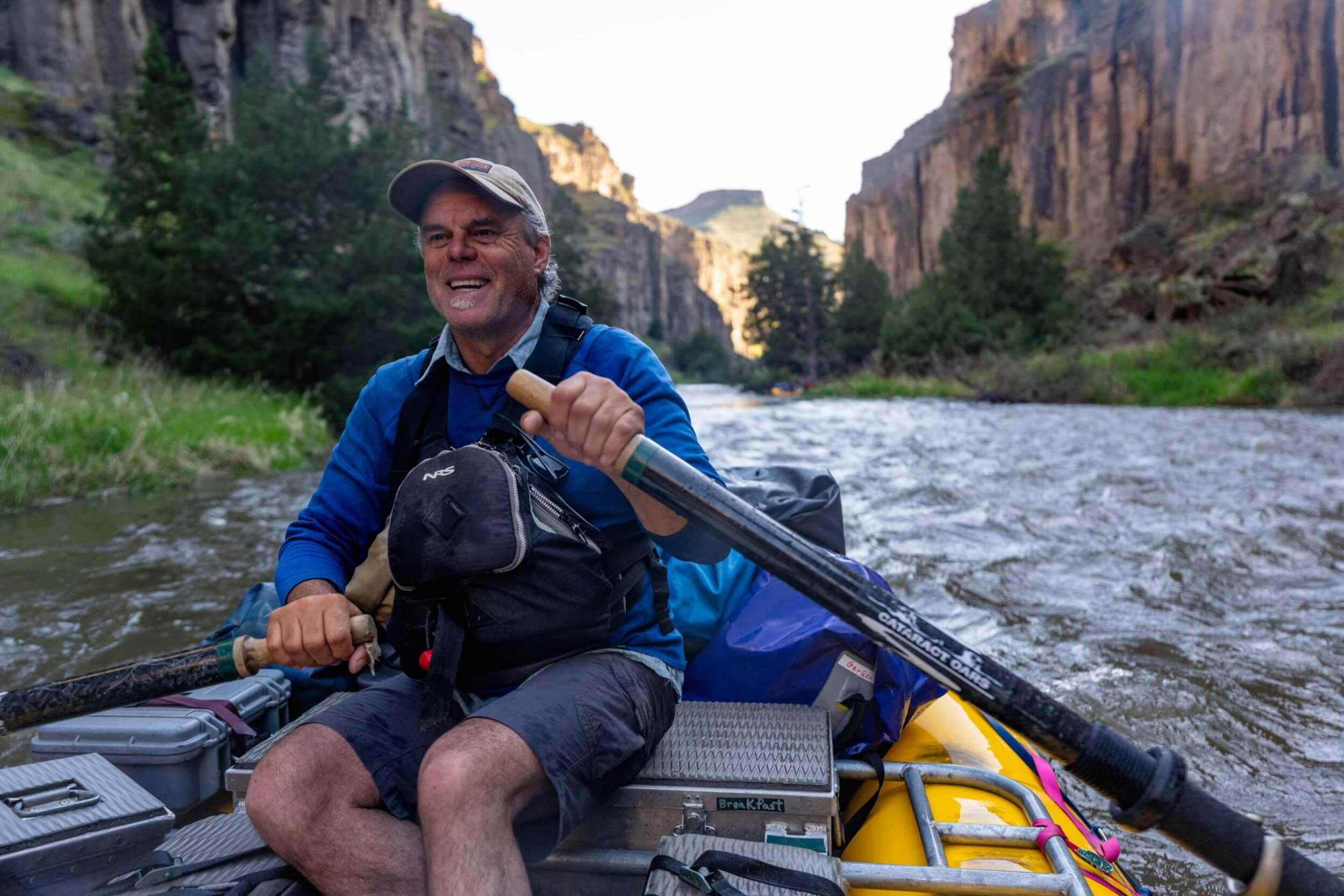 Jon Barker rows a raft down the Bruneau River canyon with gear onboard.