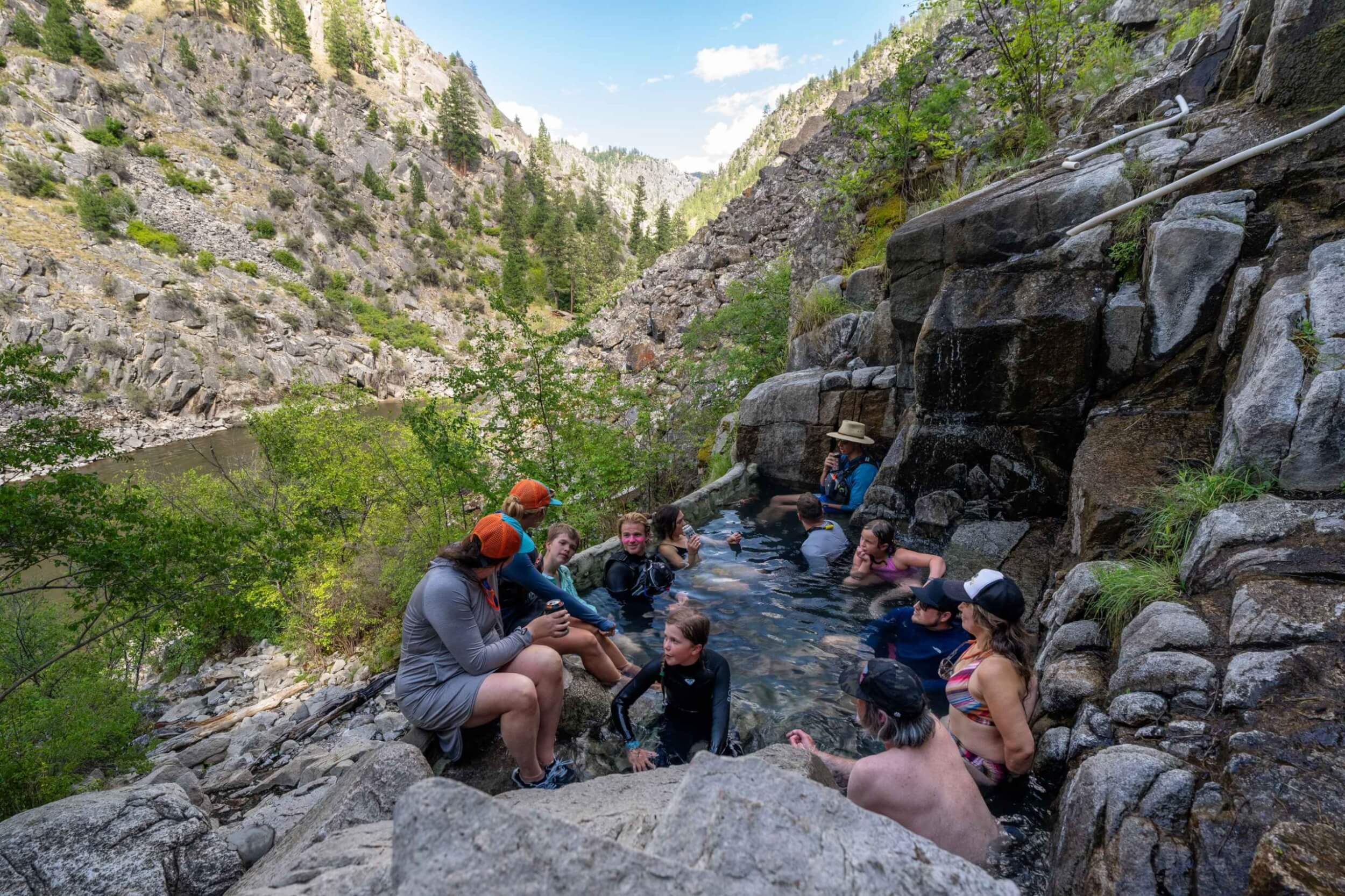 Group of rafters soaking in a natural hot spring above the Main Salmon River.