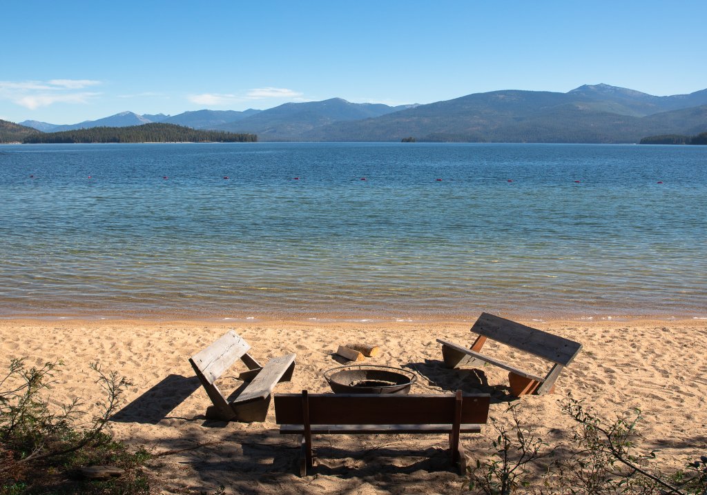 TRAVEL WITH CARE: CAMPFIRE SAFETY A fire ring and benches on a Priest Lake beach.