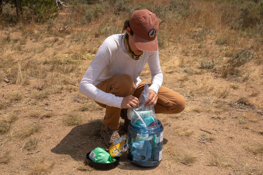 Travel With Care: Safety in Bear Country A hiker places her food, toiletries and trash in a bear-safe container.
