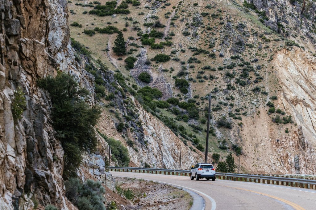 A car drives around a corner along the Wildlife Canyon Scenic Byway.