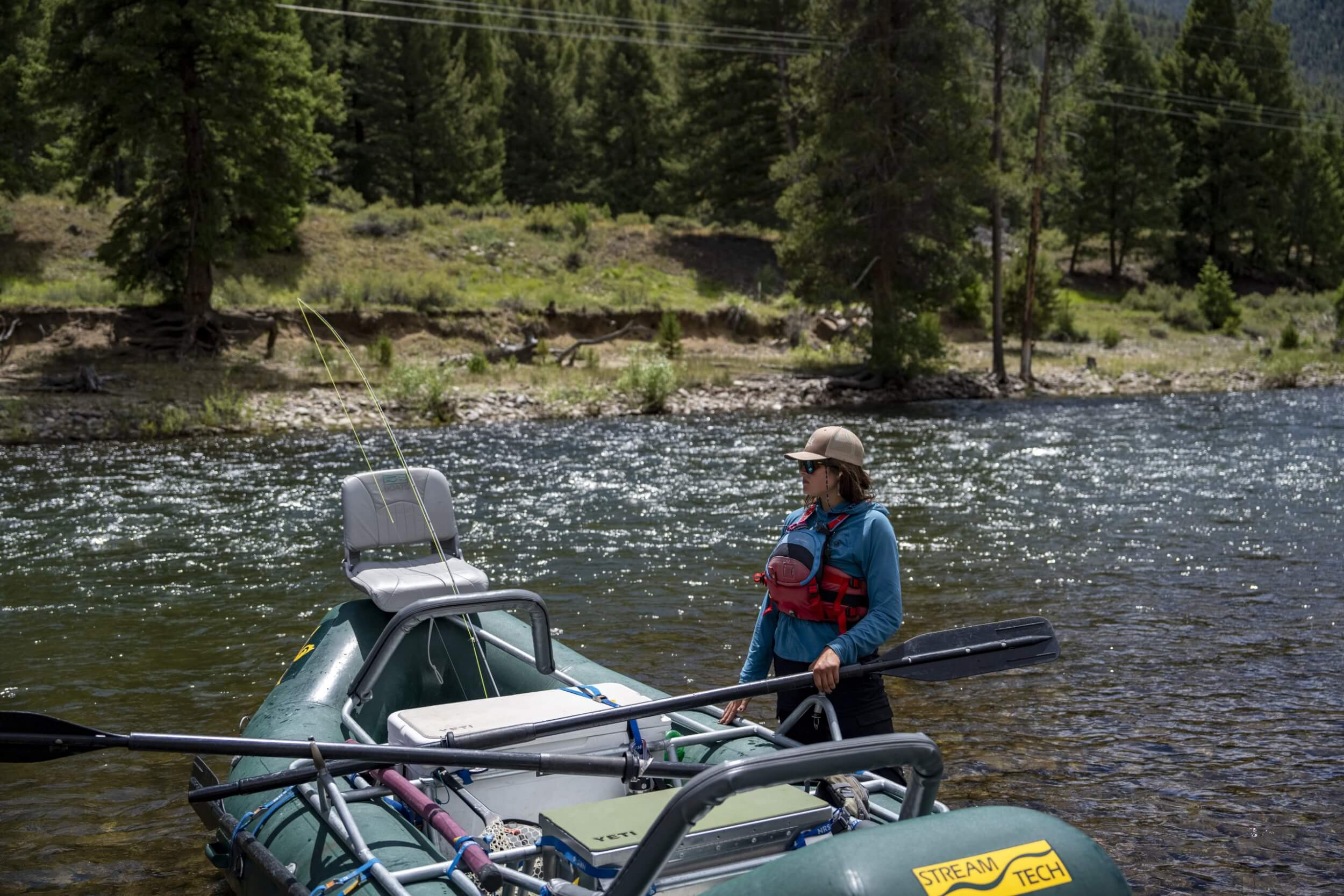 Don’t Skip a Guided Fly-Fishing Trip in Stanley river fly-fishing guide stands next to raft in Idaho