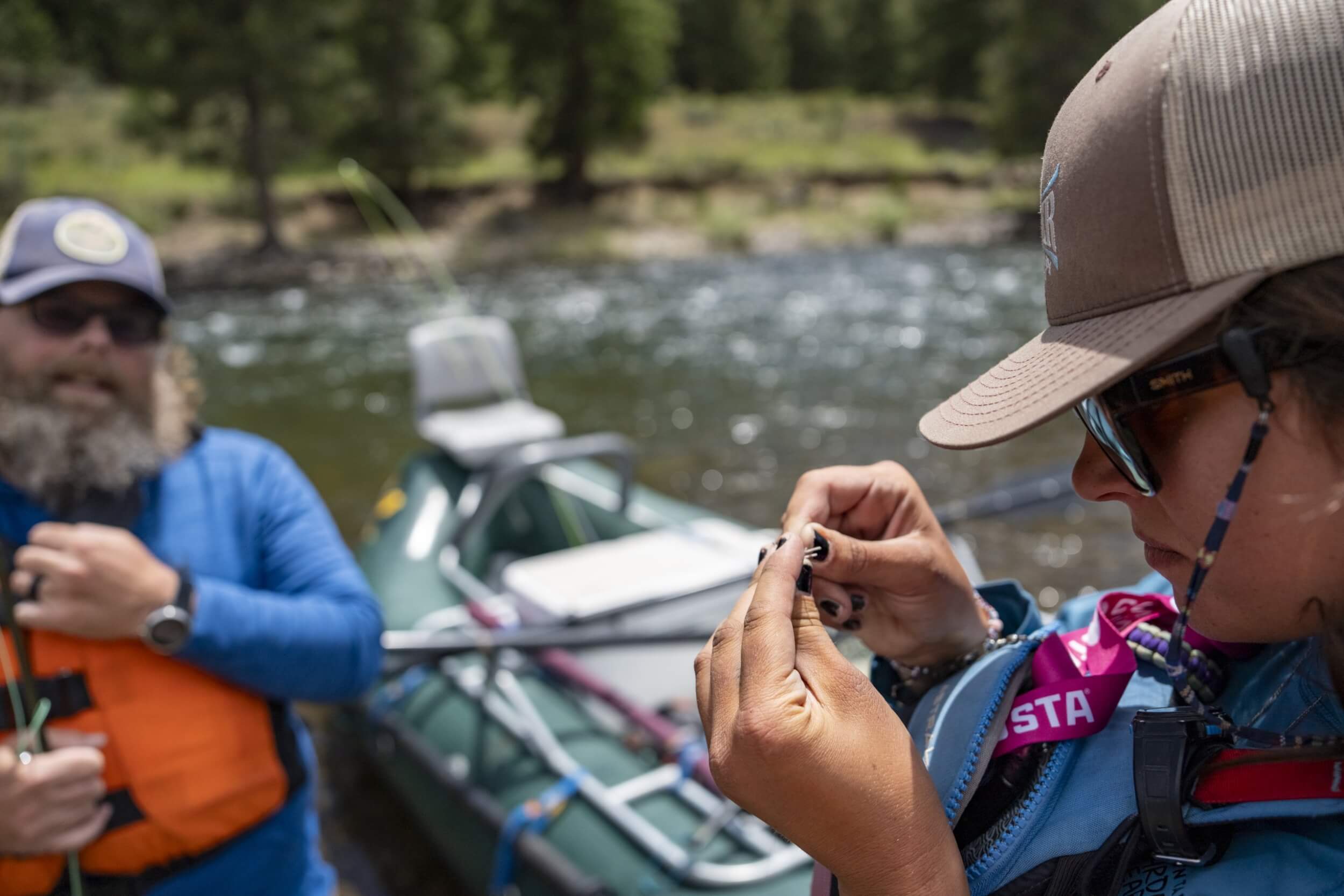 Don’t Skip a Guided Fly-Fishing Trip in Stanley woman ties fly onto fly-fishing rod on guided fishing trip on Salmon River