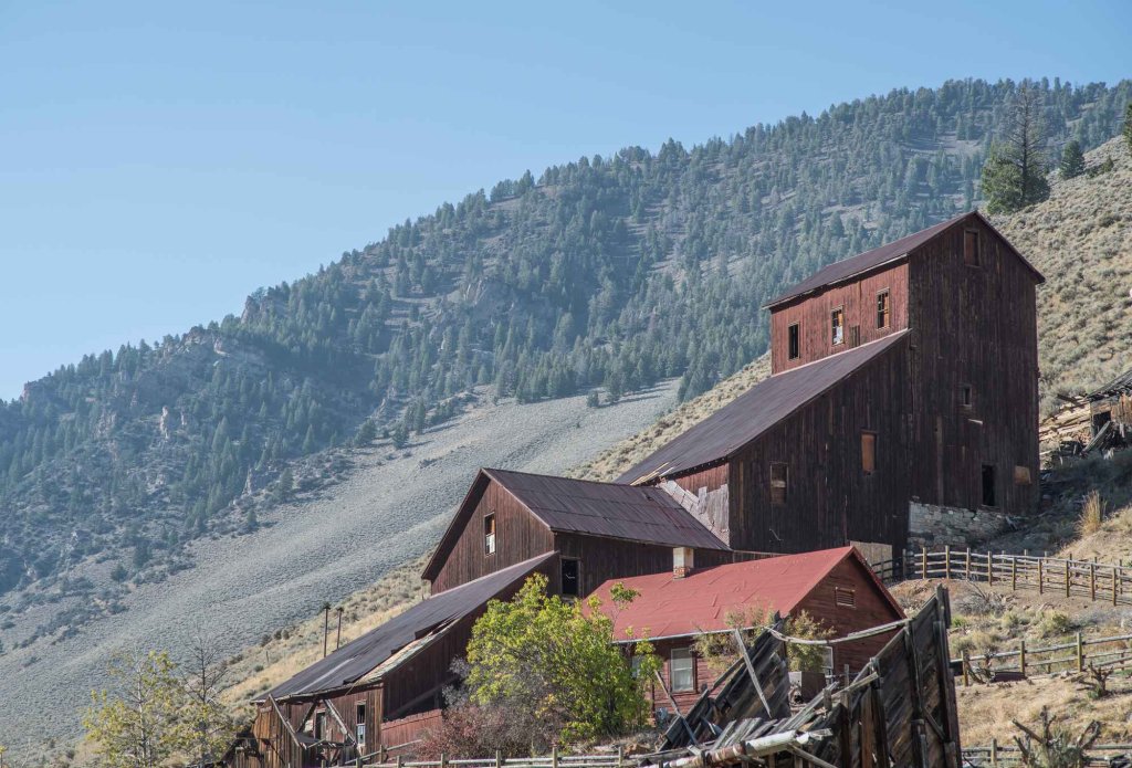Historic mining structure with red and brown wood siding at Bayhorse Ghost Town.