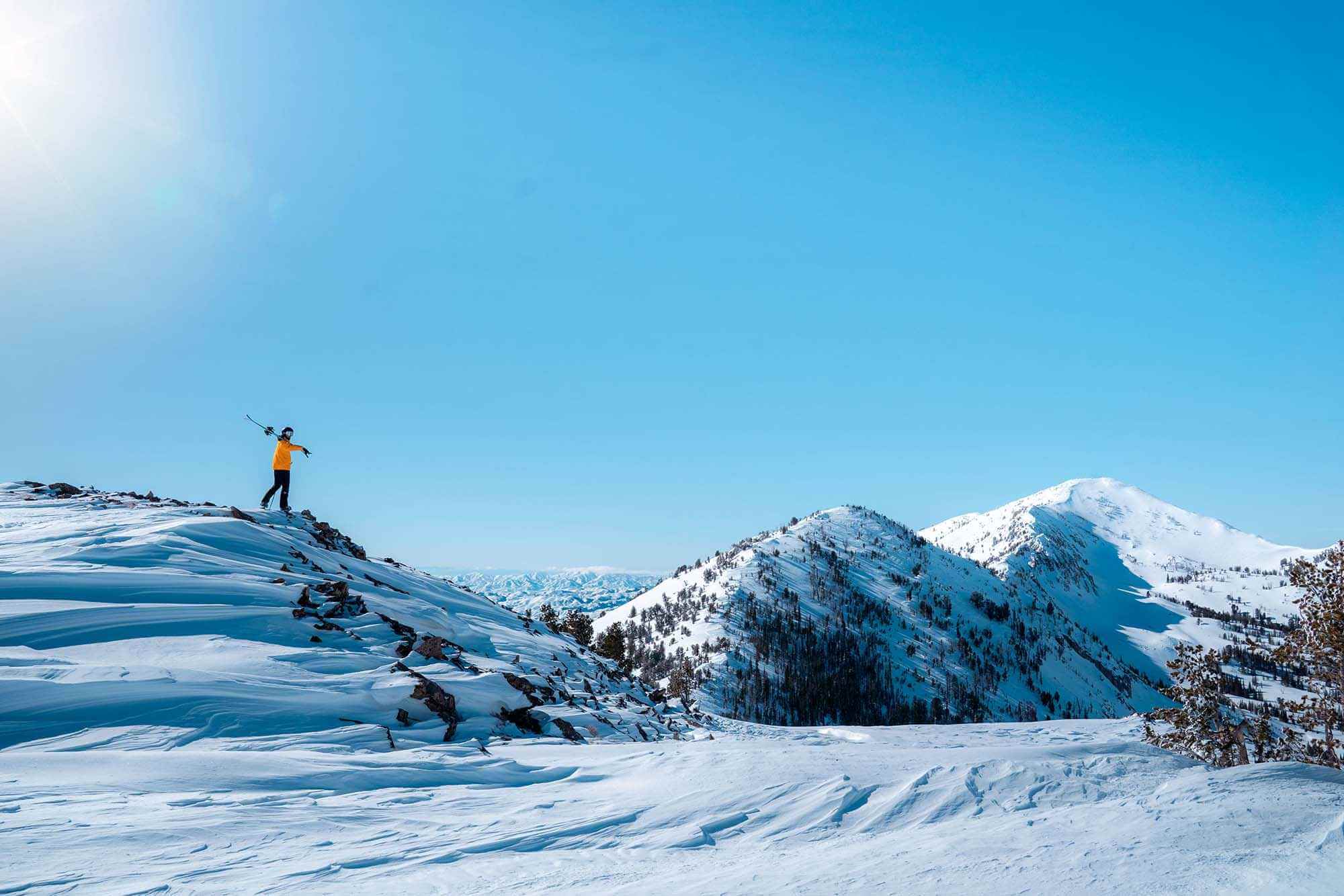 Backcountry TRAX skier at the summit of Soldier Mountain, surrounded by snowy peaks in South Central Idaho.