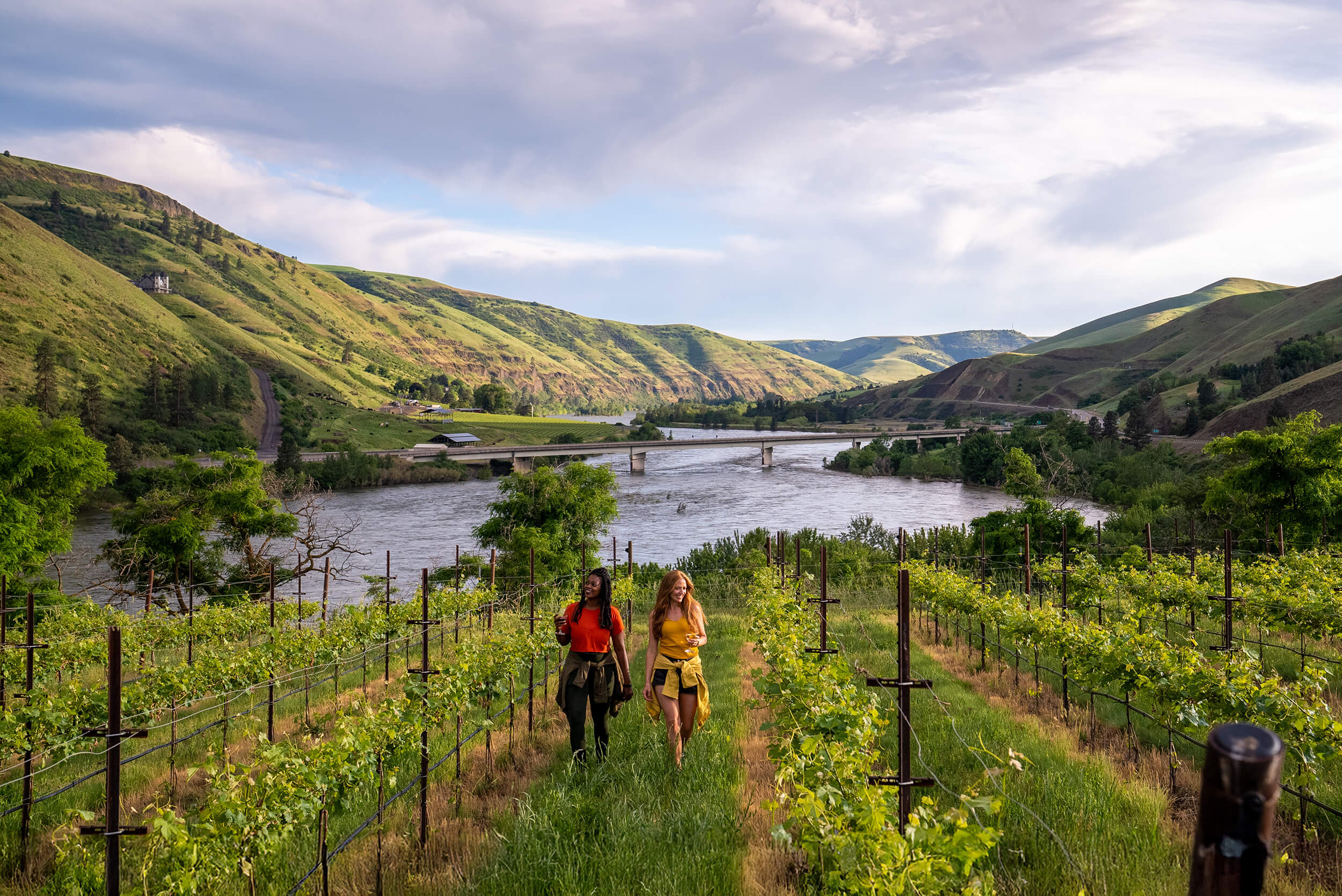 Two women walking through the Rivaura Estate Vineyard & Winery overlooking the Clearwater River.