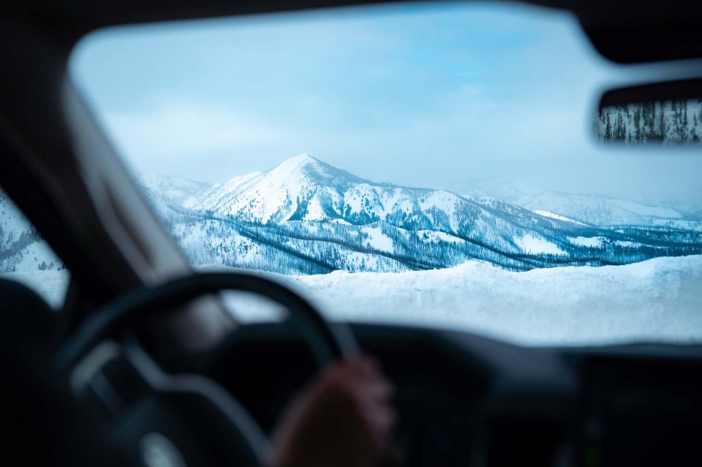 Snow-covered mountain view seen from inside a vehicle