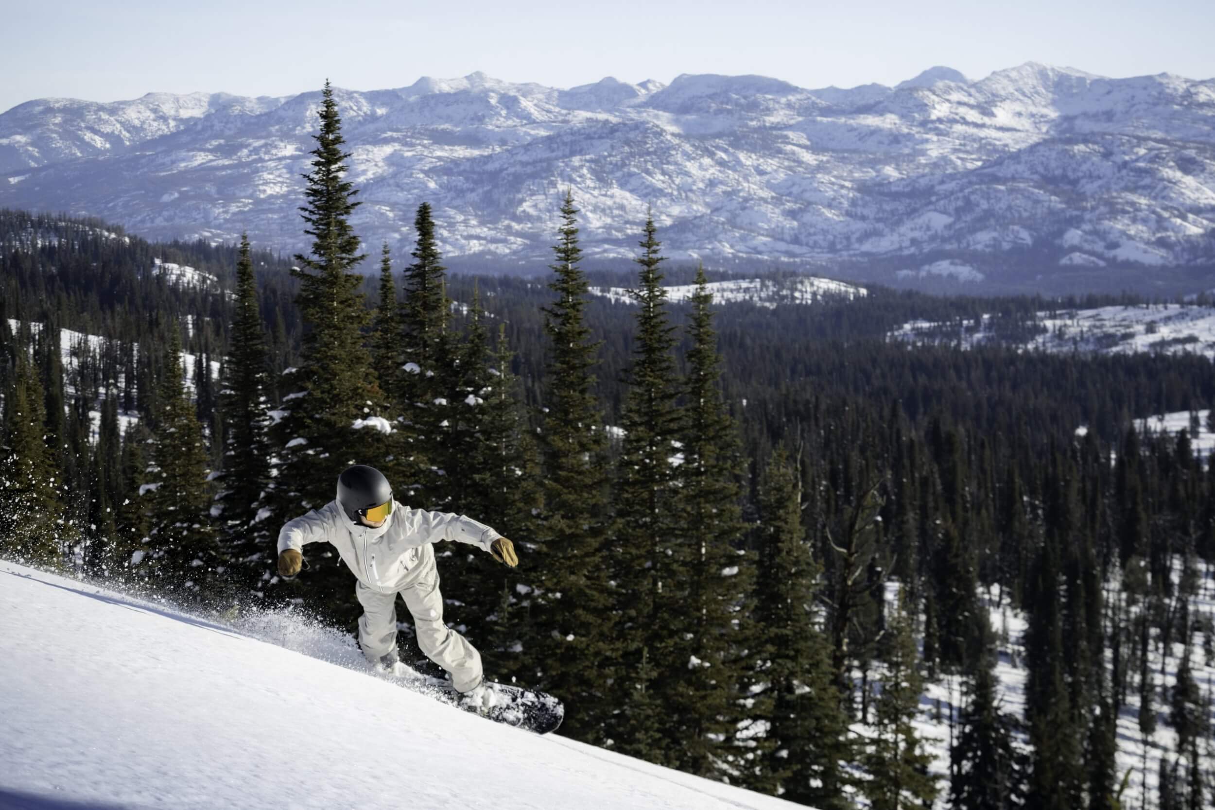 A person in white snowboards down a slope at Brundage Mountain Resort.