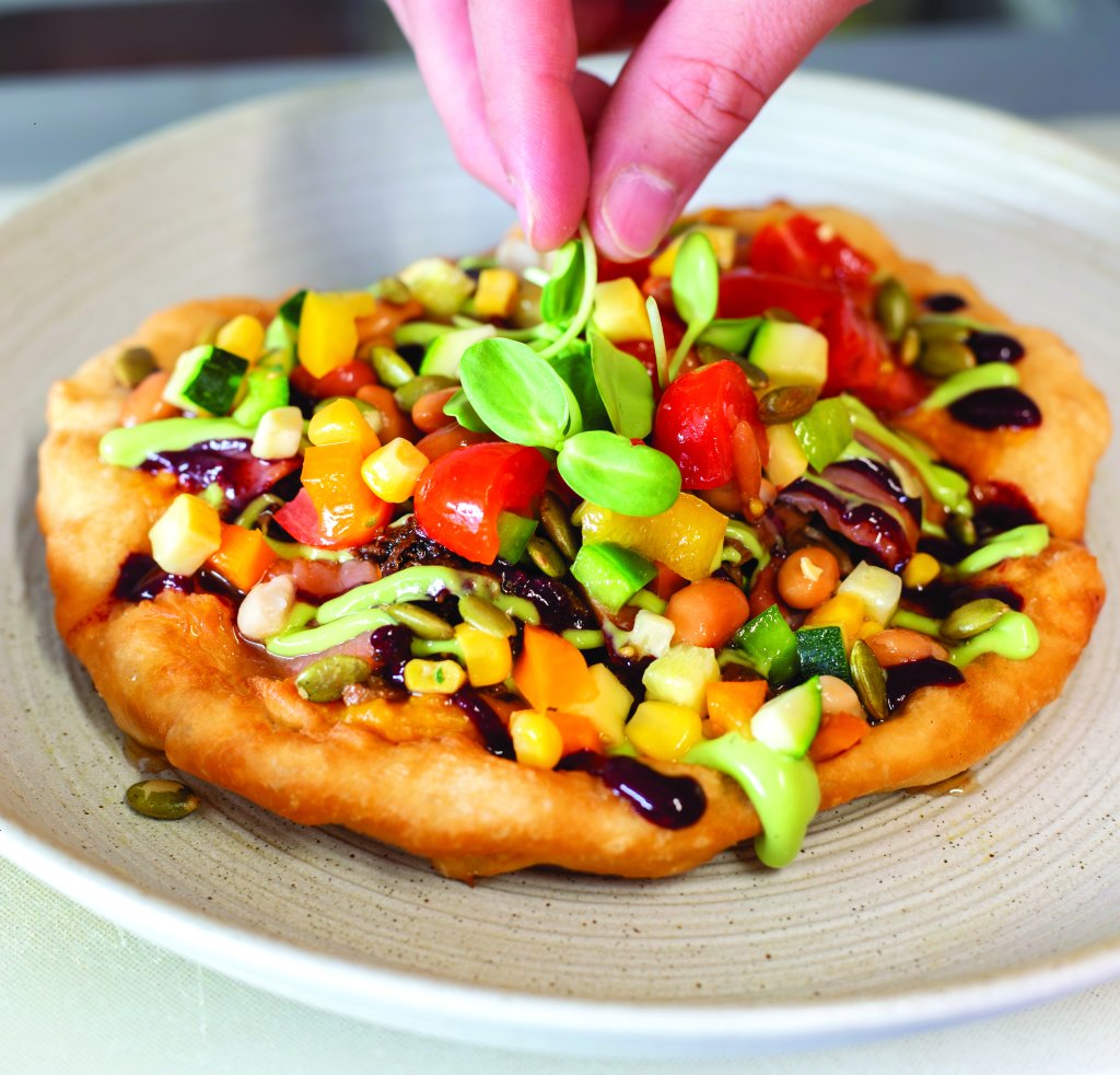 A bowl of colorful veggies, beans in an Native American inspired dish..
