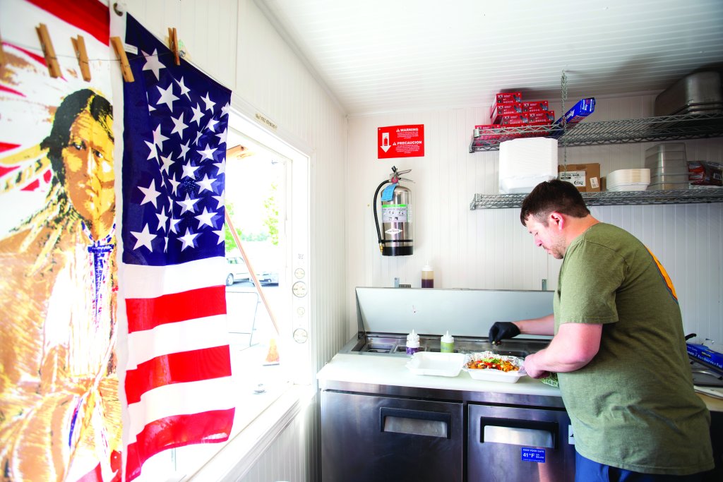 Chef prepares to serve up food while working in a food truck.