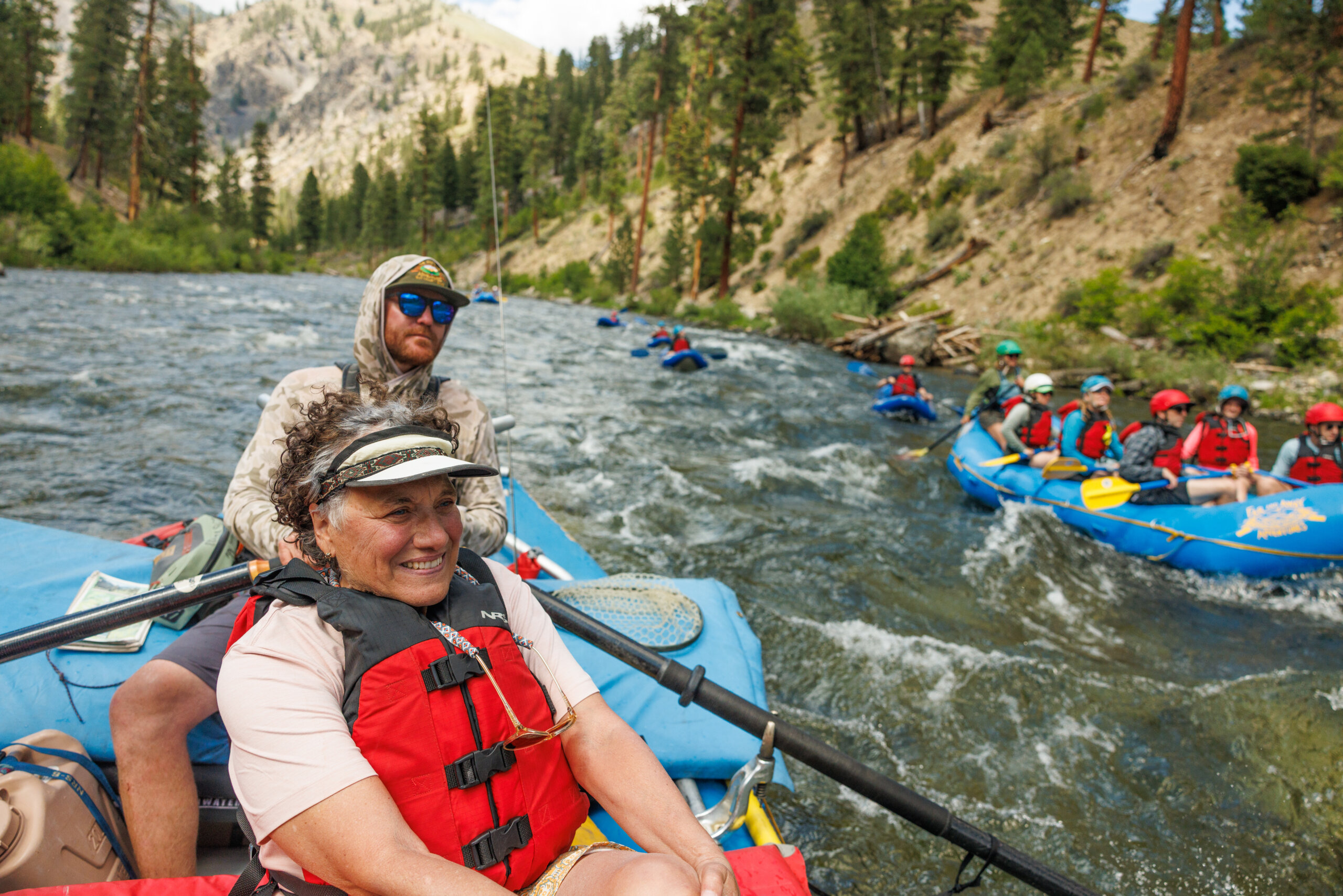 lady sits on raft on guided trip on middle fork salmon river. 